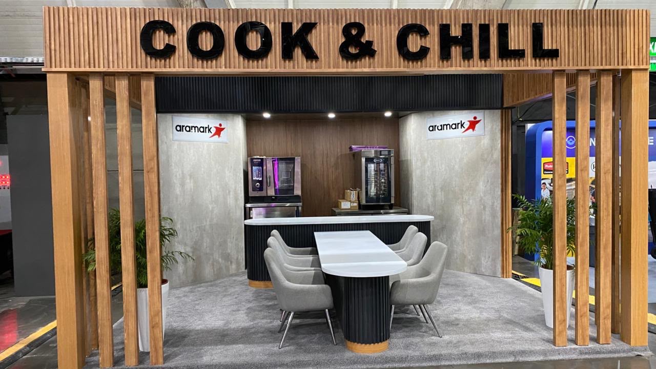 Stand para feria con estructura de madera, letrero y zona de asientos